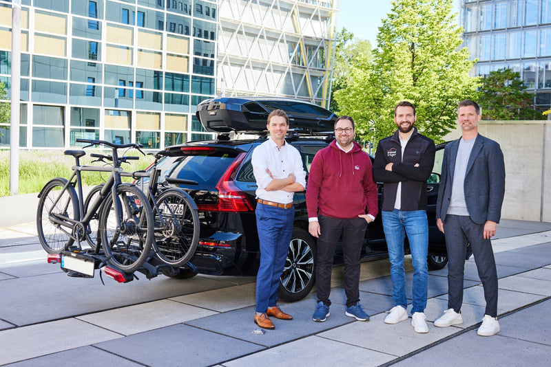 Vertreter von der LVM und travelträger vor einem PKW mit Dachbox und Fahrradträger