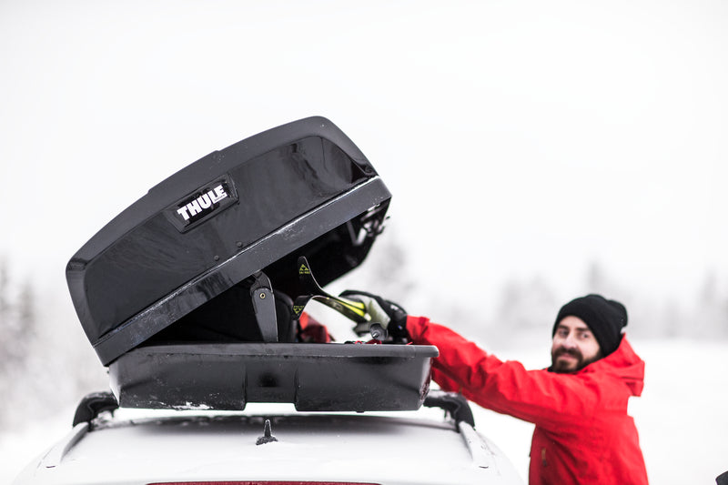 Dachbox wird in Schneekulisse beladen